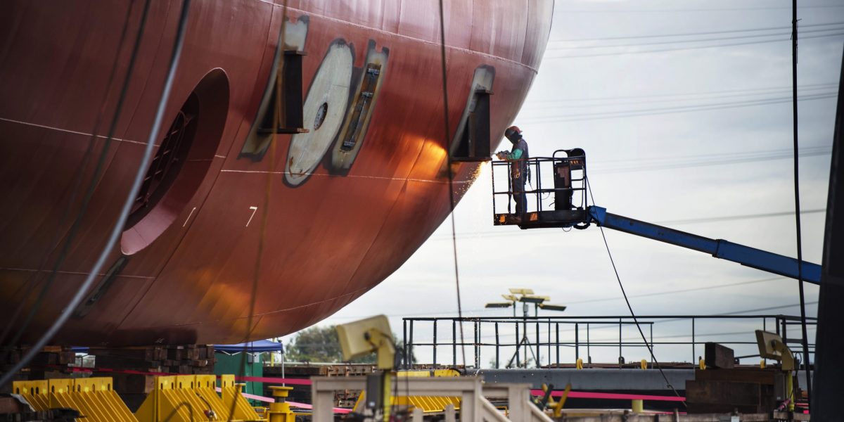 Worker repairing container ship